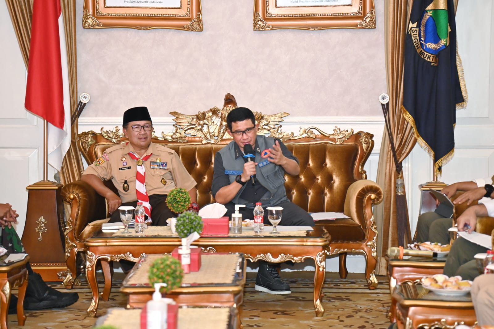 Kepala BNPB Letjen TNI Suharyanto (menggunakan rompi dan kemeja hijau) saat memimpin Rapat Evaluasi Percepatan Pelaksanaan Pembangunan Rumah Rusak bagi masyarakat terdampak gempa pada November yang lalu. Rapat ini dilaksanakan di Kantor Bupati Cianjur, Jawa Barat pada Jumat (14/7).